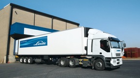 A refrigerated truck with the Linde branding outside an industrial warehouse.